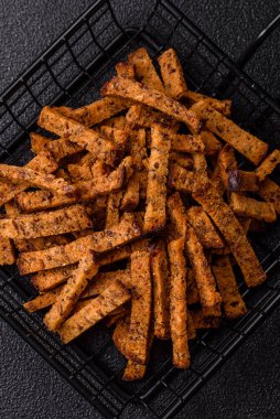 Koyu beton arka planda tohum ve tahıllı, tuzlu, baharatlı ve otlu ev yapımı kahverengi ekmek krakerleri veya kızarmış ekmekler.