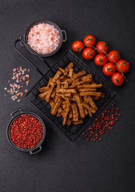 Koyu beton arka planda tohum ve tahıllı, tuzlu, baharatlı ve otlu ev yapımı kahverengi ekmek krakerleri veya kızarmış ekmekler.