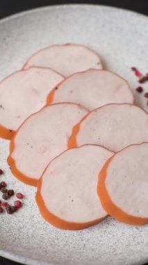 Lezzetli taze jambon, tuz, baharat ve otlarla kesilmiş koyu beton arka planda yuvarlak dilimler halinde.