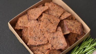 Tohumlar, tanecikler, tuz, baharatlar ve çimento kaplı ev yapımı çıtır kahverengi ekmek cipsleri.