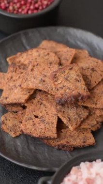 Tohumlar, tanecikler, tuz, baharatlar ve çimento kaplı ev yapımı çıtır kahverengi ekmek cipsleri.