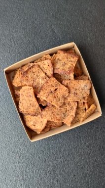 Tohumlar, tanecikler, tuz, baharatlar ve çimento kaplı ev yapımı çıtır kahverengi ekmek cipsleri.