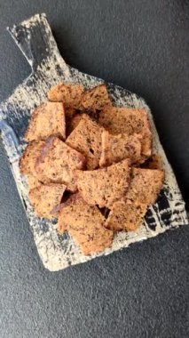 Tohumlar, tanecikler, tuz, baharatlar ve çimento kaplı ev yapımı çıtır kahverengi ekmek cipsleri.