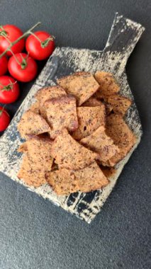 Tohumlar, tanecikler, tuz, baharatlar ve çimento kaplı ev yapımı çıtır kahverengi ekmek cipsleri.