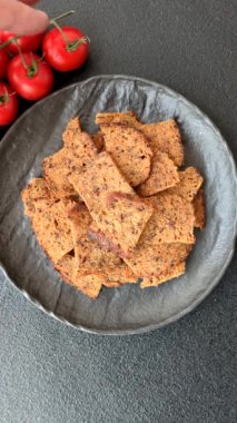 Tohumlar, tanecikler, tuz, baharatlar ve çimento kaplı ev yapımı çıtır kahverengi ekmek cipsleri.