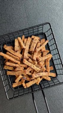 Koyu beton arka planda tohum ve tahıllı, tuzlu, baharatlı ve otlu ev yapımı kahverengi ekmek krakerleri veya kızarmış ekmekler.