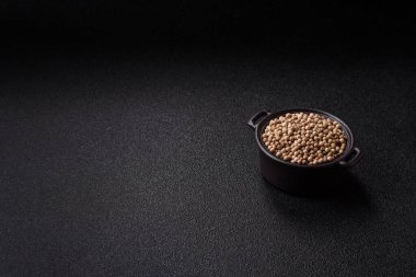 Koyu beton arka planda seramik bir kasede tüm baharatlar beyaz.