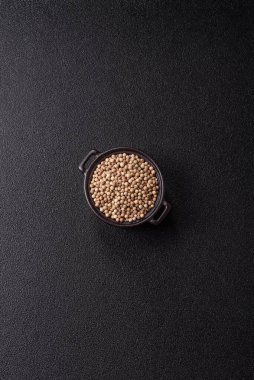 Koyu beton arka planda seramik bir kasede tüm baharatlar beyaz.