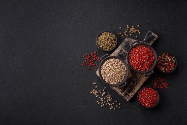 Koyu beton arka planda seramik bir kasede tüm baharatlar beyaz.