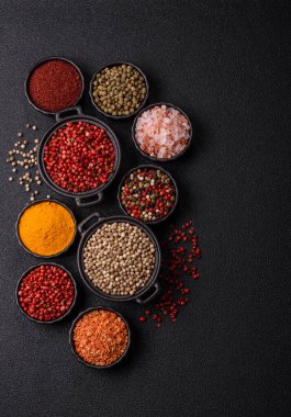 Baharat çeşitleri, tüm baharatlar, zerdeçal, paprika, koyu beton arka planda seramik kaselerde tuz.