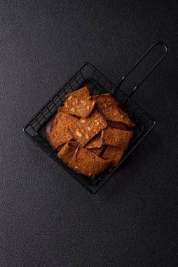 Tohumlar, tanecikler, tuz, baharatlar ve çimento kaplı ev yapımı çıtır kahverengi ekmek cipsleri.