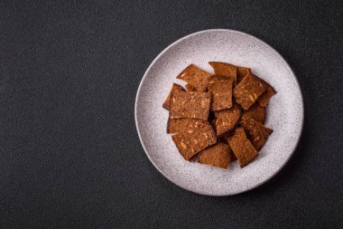 Tohumlar, tanecikler, tuz, baharatlar ve çimento kaplı ev yapımı çıtır kahverengi ekmek cipsleri.