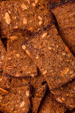 Tohumlar, tanecikler, tuz, baharatlar ve çimento kaplı ev yapımı çıtır kahverengi ekmek cipsleri.