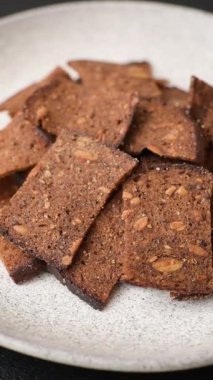 Tohumlar, tanecikler, tuz, baharatlar ve çimento kaplı ev yapımı çıtır kahverengi ekmek cipsleri.