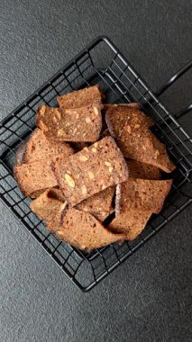 Tohumlar, tanecikler, tuz, baharatlar ve çimento kaplı ev yapımı çıtır kahverengi ekmek cipsleri.