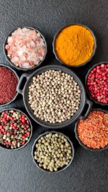 Baharat çeşitleri, tüm baharatlar, zerdeçal, paprika, koyu beton arka planda seramik kaselerde tuz.