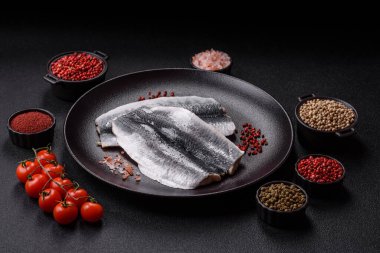 Ringa fileto tuzlu ve tuzlu, baharatlı ve yağlı koyu beton arka planda.