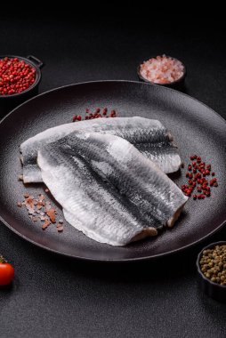 Ringa fileto tuzlu ve tuzlu, baharatlı ve yağlı koyu beton arka planda.