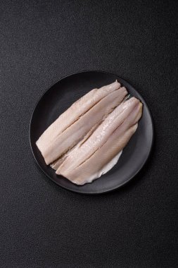 Ringa fileto tuzlu ve tuzlu, baharatlı ve yağlı koyu beton arka planda.