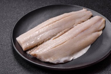 Ringa fileto tuzlu ve tuzlu, baharatlı ve yağlı koyu beton arka planda.