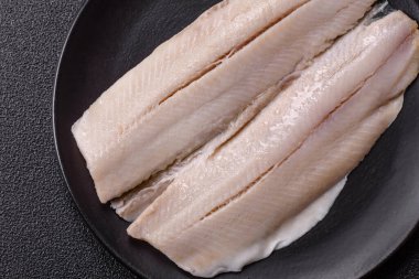 Ringa fileto tuzlu ve tuzlu, baharatlı ve yağlı koyu beton arka planda.