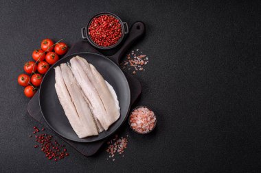 Ringa fileto tuzlu ve tuzlu, baharatlı ve yağlı koyu beton arka planda.