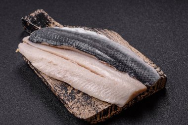 Ringa fileto tuzlu ve tuzlu, baharatlı ve yağlı koyu beton arka planda.