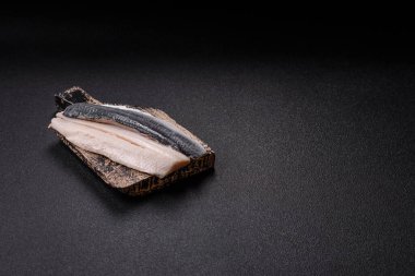 Ringa fileto tuzlu ve tuzlu, baharatlı ve yağlı koyu beton arka planda.