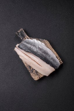 Ringa fileto tuzlu ve tuzlu, baharatlı ve yağlı koyu beton arka planda.