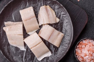 Ringa fileto tuzlu ve tuzlu, baharatlı ve yağlı koyu beton arka planda.