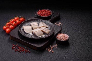 Ringa fileto tuzlu ve tuzlu, baharatlı ve yağlı koyu beton arka planda.