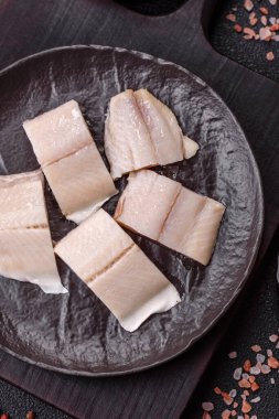 Ringa fileto tuzlu ve tuzlu, baharatlı ve yağlı koyu beton arka planda.