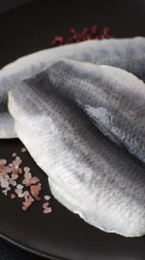 Ringa fileto tuzlu ve tuzlu, baharatlı ve yağlı koyu beton arka planda.