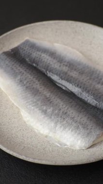 Ringa fileto tuzlu ve tuzlu, baharatlı ve yağlı koyu beton arka planda.