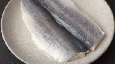 Ringa fileto tuzlu ve tuzlu, baharatlı ve yağlı koyu beton arka planda.