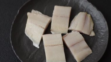 Ringa fileto tuzlu ve tuzlu, baharatlı ve yağlı koyu beton arka planda.