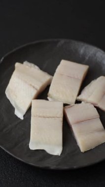 Ringa fileto tuzlu ve tuzlu, baharatlı ve yağlı koyu beton arka planda.