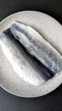 Ringa fileto tuzlu ve tuzlu, baharatlı ve yağlı koyu beton arka planda.