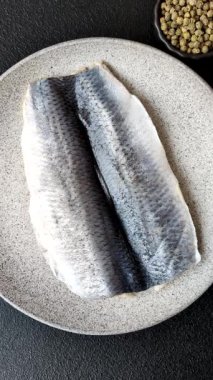 Ringa fileto tuzlu ve tuzlu, baharatlı ve yağlı koyu beton arka planda.