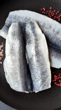 Ringa fileto tuzlu ve tuzlu, baharatlı ve yağlı koyu beton arka planda.