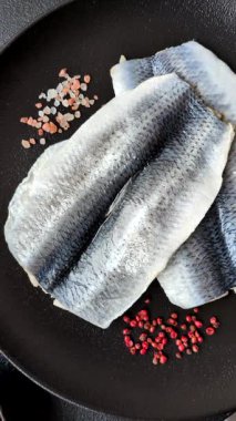 Ringa fileto tuzlu ve tuzlu, baharatlı ve yağlı koyu beton arka planda.