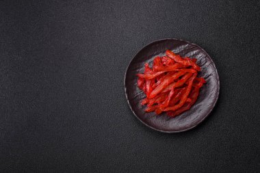 Kurutulmuş tavuk dilimleri, kurutulmuş et, kiraz ya da erik aromalı, tuzlu ve baharatlı koyu beton arka planda.