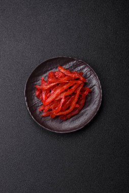 Kurutulmuş tavuk dilimleri, kurutulmuş et, kiraz ya da erik aromalı, tuzlu ve baharatlı koyu beton arka planda.