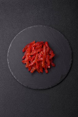 Kurutulmuş tavuk dilimleri, kurutulmuş et, kiraz ya da erik aromalı, tuzlu ve baharatlı koyu beton arka planda.