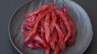 Kurutulmuş tavuk dilimleri, kurutulmuş et, kiraz ya da erik aromalı, tuzlu ve baharatlı koyu beton arka planda.