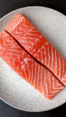 Izgara pişirme için baharatlı ve otlu taze çiğ somon bifteği. Sağlıklı deniz ürünleri