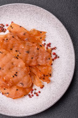 Kurutulmuş, tuzlu ve baharatlı kurutulmuş tavuk eti, koyu beton arka planda.