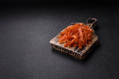 Kurutulmuş hindi eti, tuzlu ve baharatlı koyu beton arka planda.