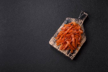 Kurutulmuş hindi eti, tuzlu ve baharatlı koyu beton arka planda.