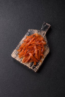 Kurutulmuş hindi eti, tuzlu ve baharatlı koyu beton arka planda.